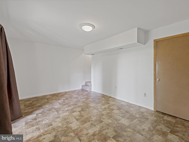 spare room with baseboards and stone finish flooring