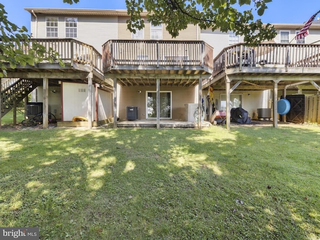 rear view of house with a lawn, a deck, and central AC