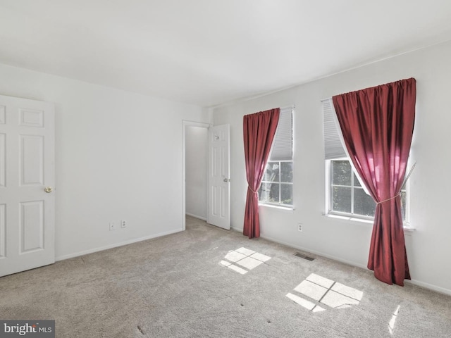 carpeted empty room with baseboards and visible vents