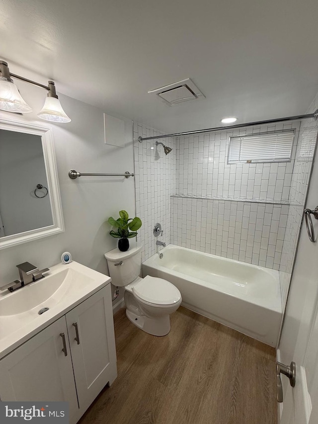 full bathroom featuring visible vents, vanity, wood finished floors, toilet, and bathtub / shower combination