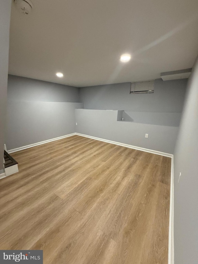 finished below grade area with recessed lighting, baseboards, and wood finished floors