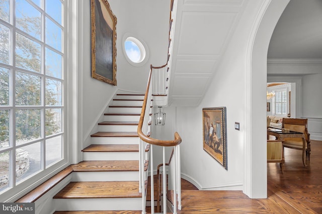 6068 Stoney Hill Rd, New Hope, PA 18938 - staircase with crown molding, wood finished floors, a chandelier, arched walkways, and baseboards