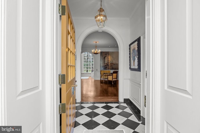 6068 Stoney Hill Rd, New Hope, PA 18938 - hallway featuring arched walkways, dark floors, ornamental molding, and a notable chandelier