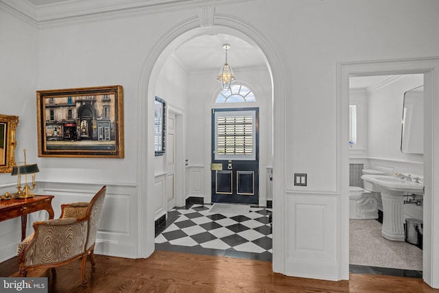 6068 Stoney Hill Rd, New Hope, PA 18938 - foyer with a decorative wall, wainscoting, arched walkways, dark floors, and ornamental molding