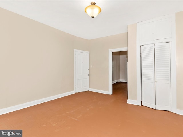 unfurnished bedroom with baseboards, carpet, and a closet