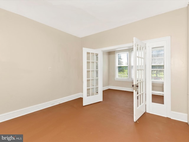 spare room featuring french doors and baseboards