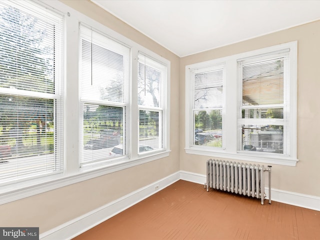 unfurnished sunroom with plenty of natural light and radiator