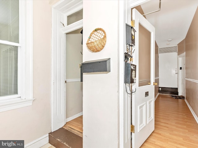 hall featuring baseboards and wood finished floors