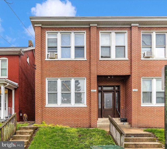 townhome / multi-family property with brick siding and cooling unit