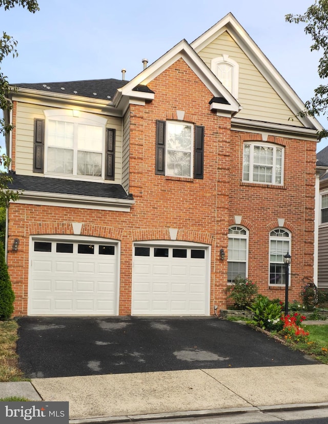 view of front facade with an attached garage, driveway, and brick siding