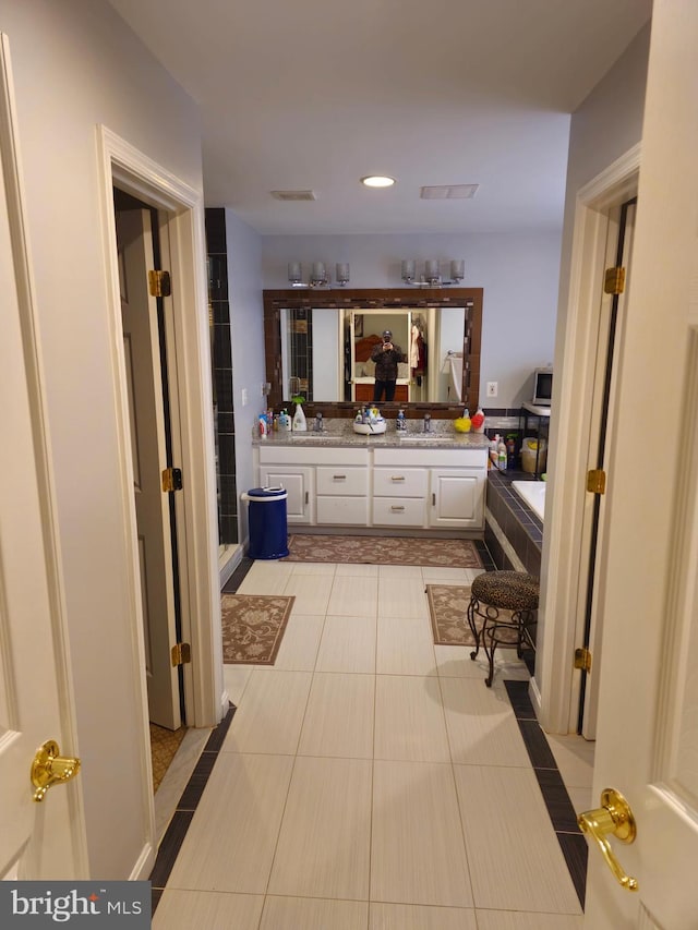 full bath featuring visible vents, recessed lighting, vanity, tile patterned floors, and a washtub