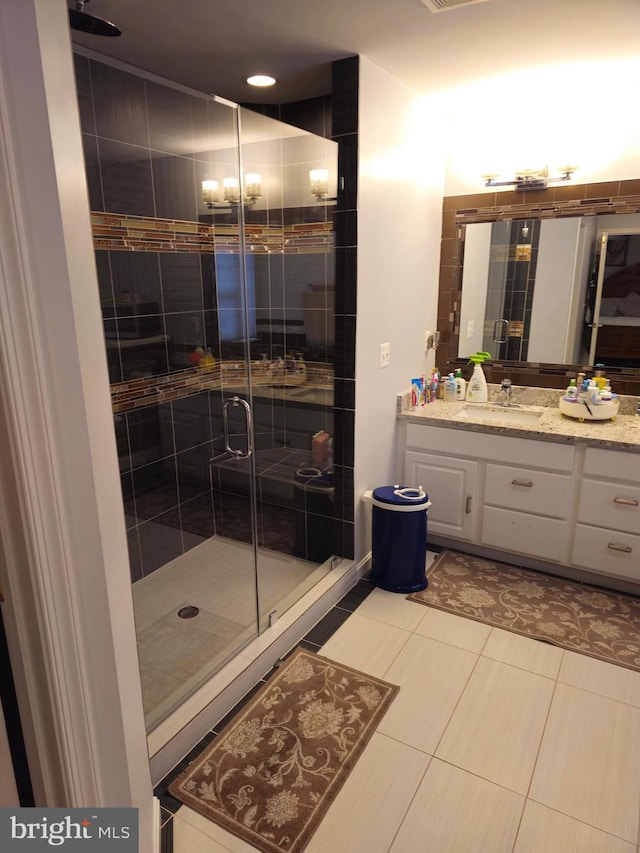 bathroom with a stall shower, vanity, and tile patterned floors