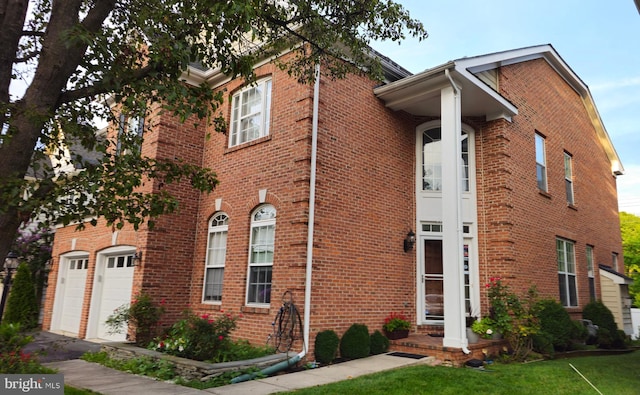 view of front of property featuring a garage, a front yard, and brick siding