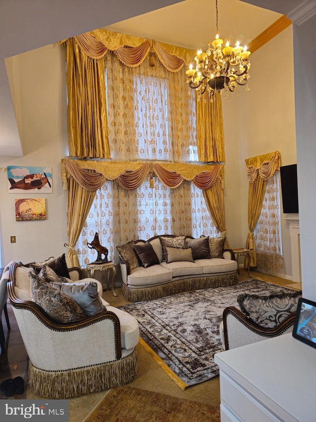 living area featuring ornamental molding, an inviting chandelier, and a towering ceiling