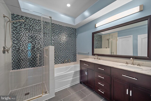 bathroom featuring a stall shower, a bath, double vanity, and tile patterned floors