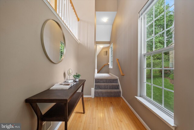 foyer featuring light wood-style floors, baseboards, and stairs