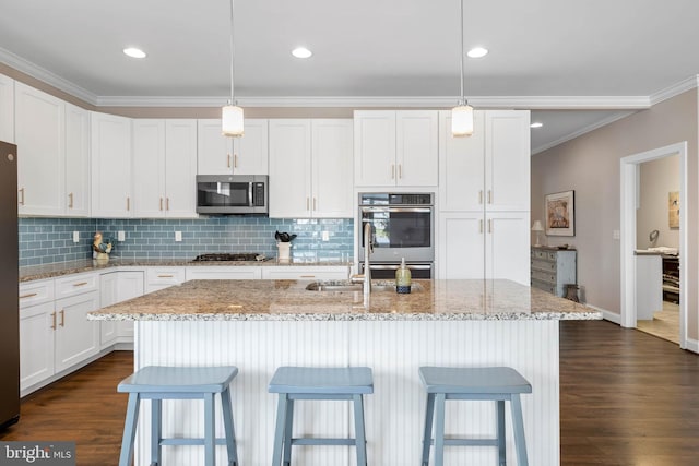 kitchen featuring white cabinets, dark wood finished floors, stainless steel appliances, crown molding, and tasteful backsplash