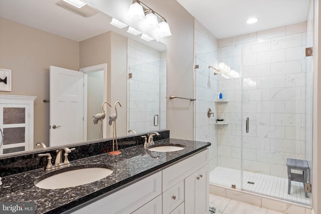 bathroom featuring double vanity, visible vents, a stall shower, and a sink
