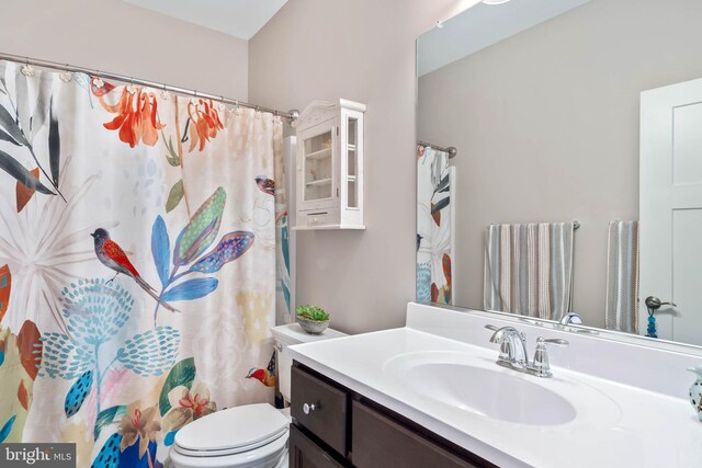 bathroom with a shower with shower curtain, toilet, and vanity