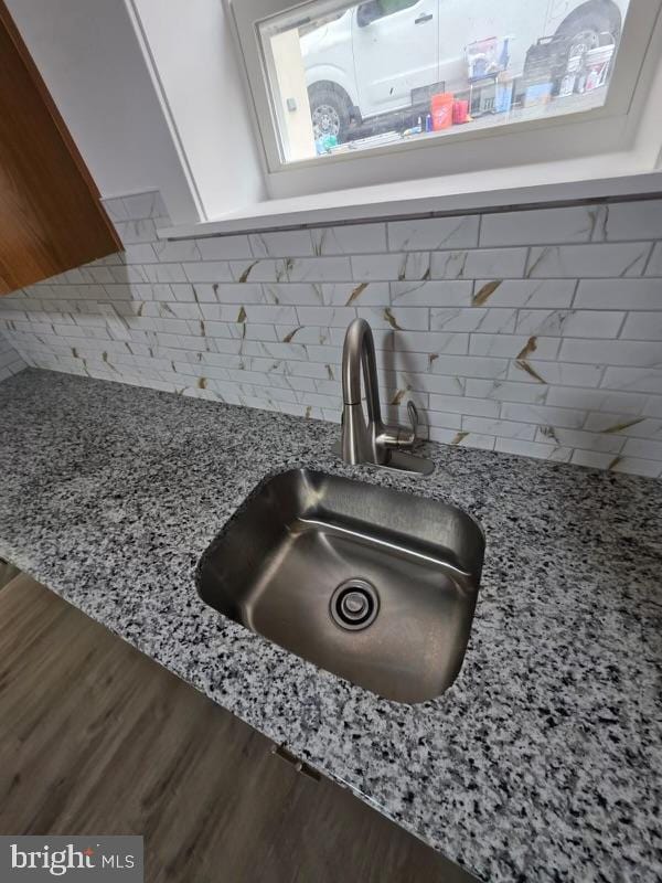 607 N 8th St, Pottsville, PA 17901 - interior details featuring light stone counters, wood finished floors, decorative backsplash, and a sink