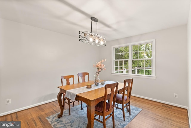 dining space with visible vents, baseboards, and wood finished floors
