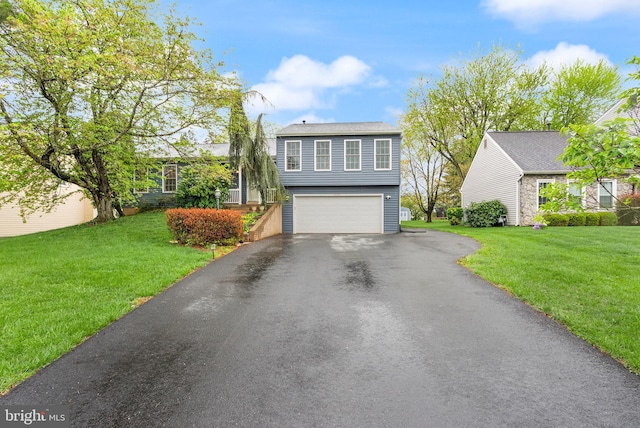 tri-level home featuring an attached garage, aphalt driveway, and a front yard