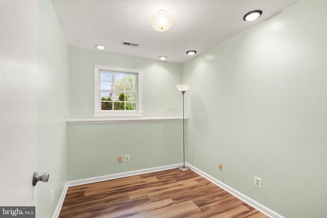 empty room with visible vents, baseboards, and wood finished floors