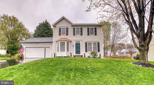 view of front of home with a front yard, a garage, and concrete driveway