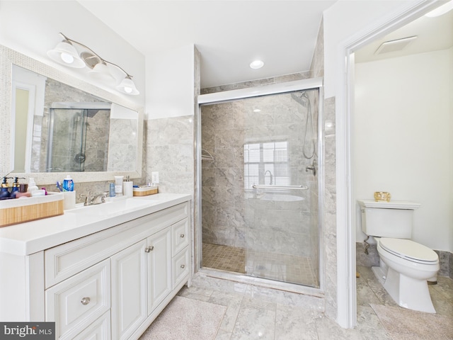 bathroom with a stall shower, toilet, and vanity