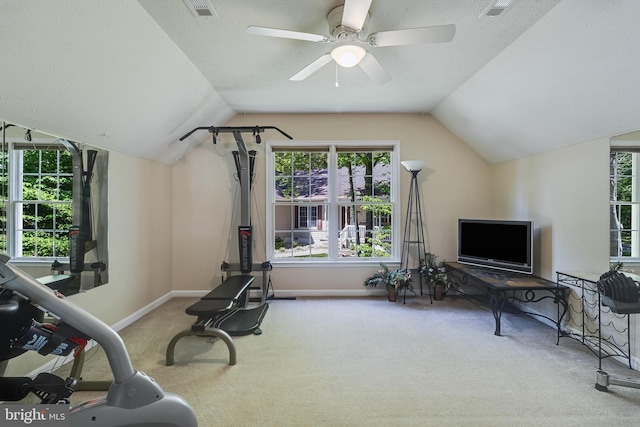 exercise room featuring ceiling fan, visible vents, vaulted ceiling, baseboards, and carpet