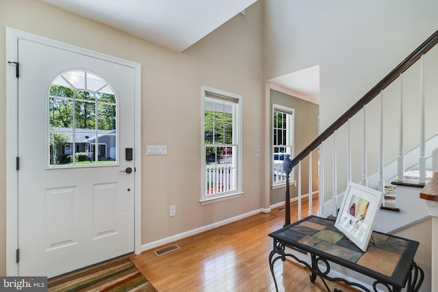 foyer with baseboards, visible vents, a wealth of natural light, and light wood-type flooring