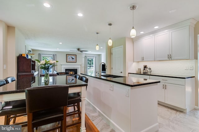 kitchen with recessed lighting, a ceiling fan, an island with sink, and a sink