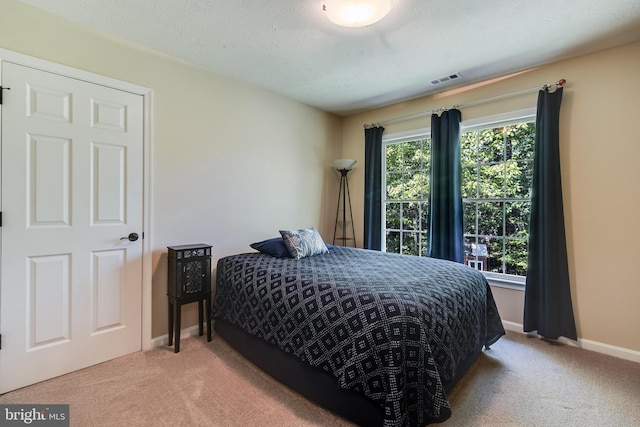 carpeted bedroom featuring baseboards and visible vents