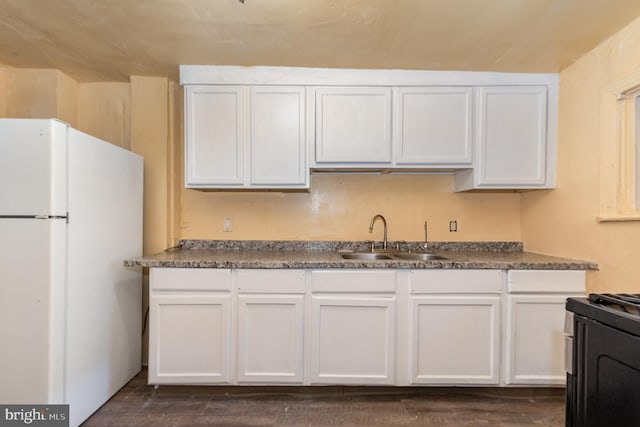 1228 Derry St, Harrisburg, PA 17104 - kitchen with white cabinetry, a sink, freestanding refrigerator, range with gas cooktop, and dark wood-type flooring