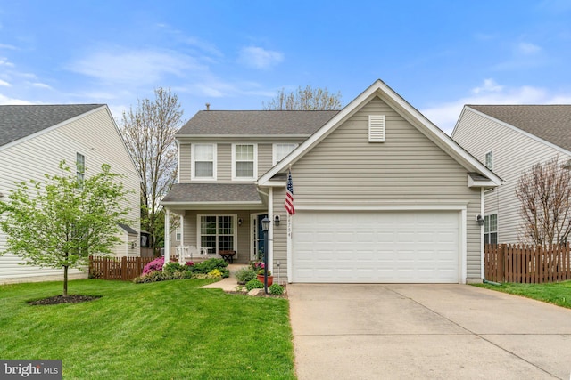 traditional-style house with fence, a front yard, driveway, and a garage