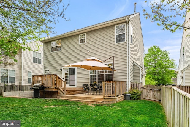 back of house with a lawn, a deck, a gate, and a fenced backyard