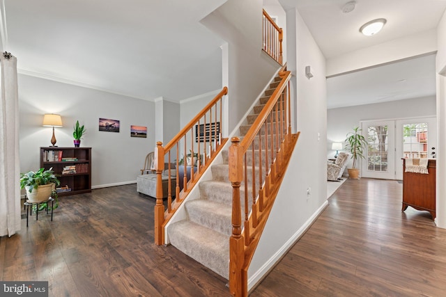 stairway featuring baseboards, ornamental molding, and wood finished floors