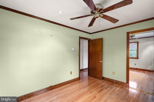 unfurnished room with baseboards, a ceiling fan, light wood-style flooring, and a textured ceiling