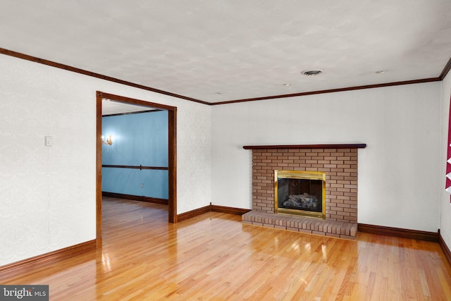 unfurnished living room featuring crown molding, a fireplace, baseboards, wood finished floors, and visible vents