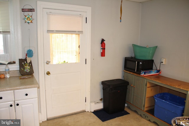 doorway to outside with a baseboard radiator and a healthy amount of sunlight