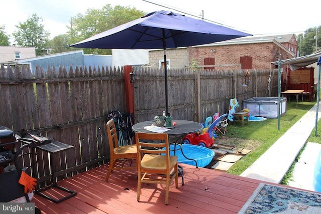 wooden deck with a fenced backyard