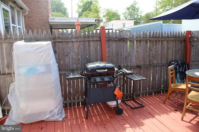 wooden deck with fence and a grill