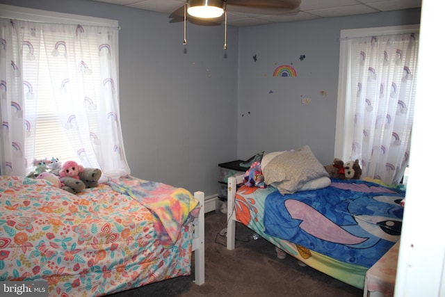 carpeted bedroom with a paneled ceiling, ceiling fan, and multiple windows