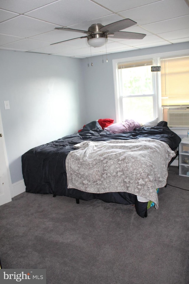 carpeted bedroom featuring a ceiling fan, a drop ceiling, and cooling unit