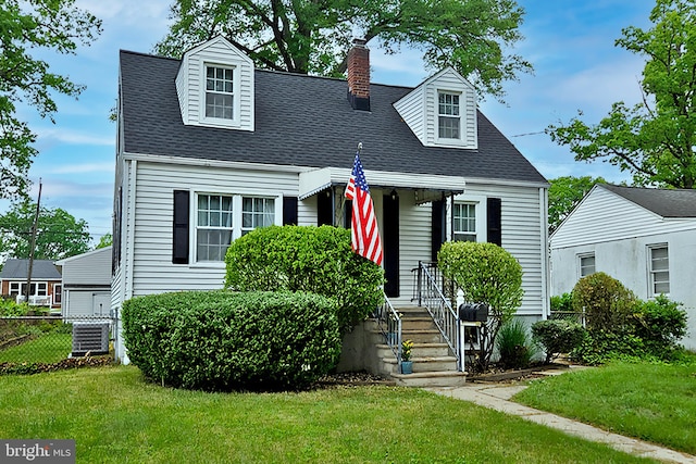 cape cod house featuring a chimney and roof with shingles