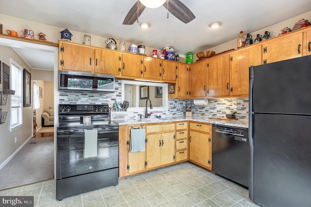 kitchen with black appliances, a sink, ceiling fan, decorative backsplash, and brown cabinets