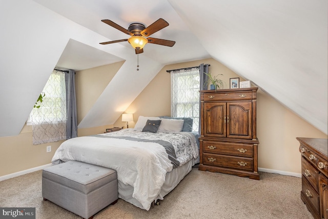 bedroom featuring vaulted ceiling, light carpet, baseboards, and a ceiling fan