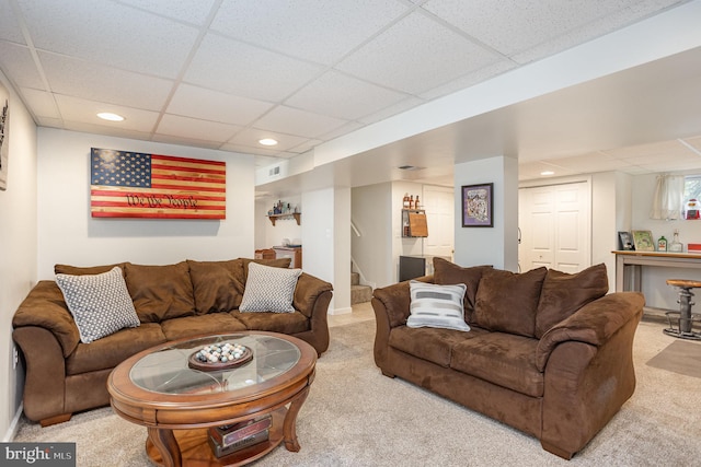 living area with a paneled ceiling, carpet flooring, stairway, and recessed lighting