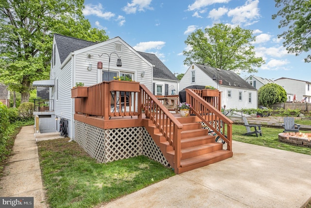 back of house featuring a wooden deck, a fire pit, stairway, a shingled roof, and fence