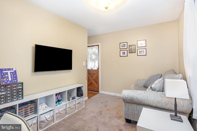 carpeted living area featuring baseboards